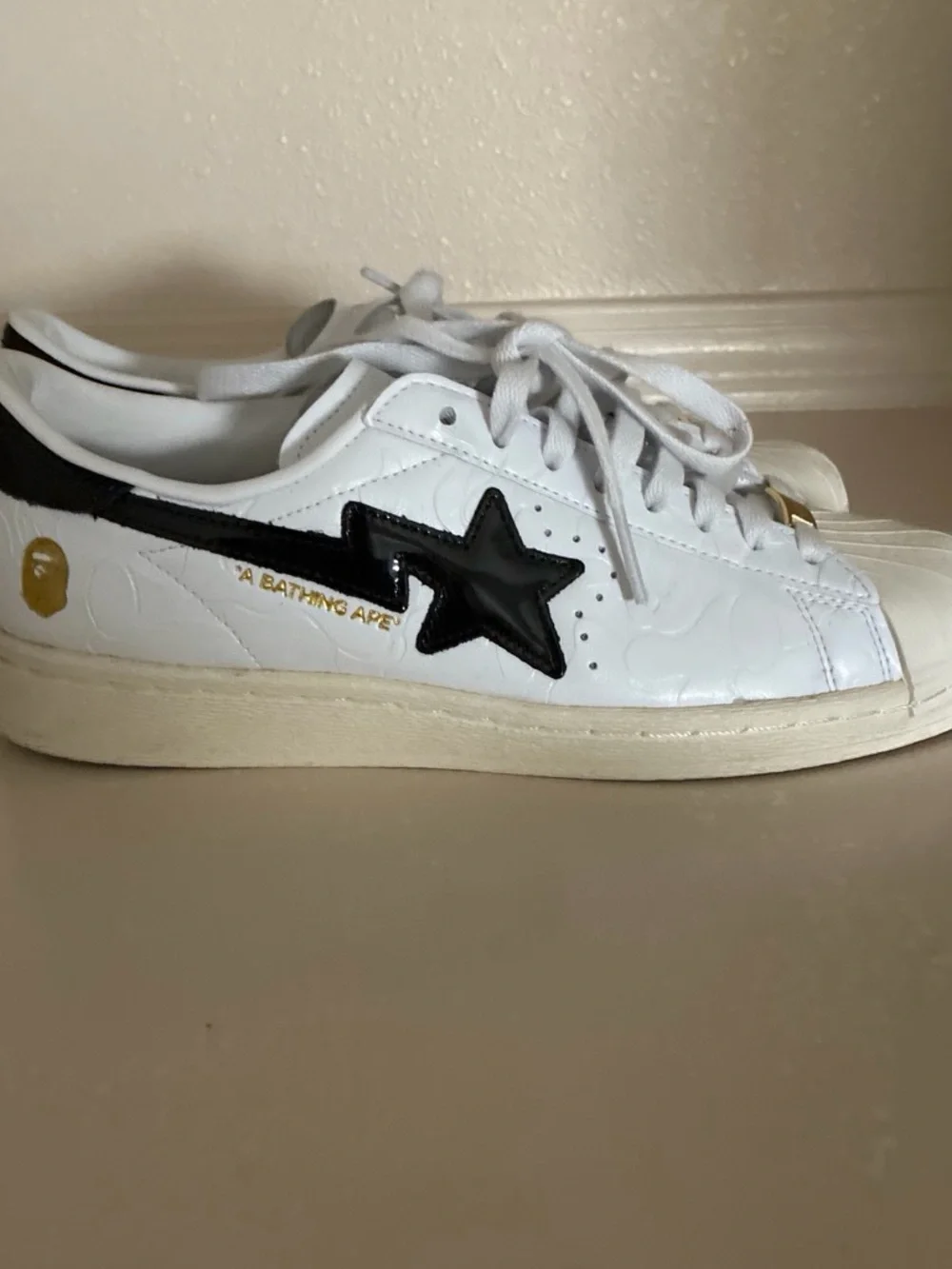 Bape White Sneakers with Black Stripes and Gold Tongue Accents