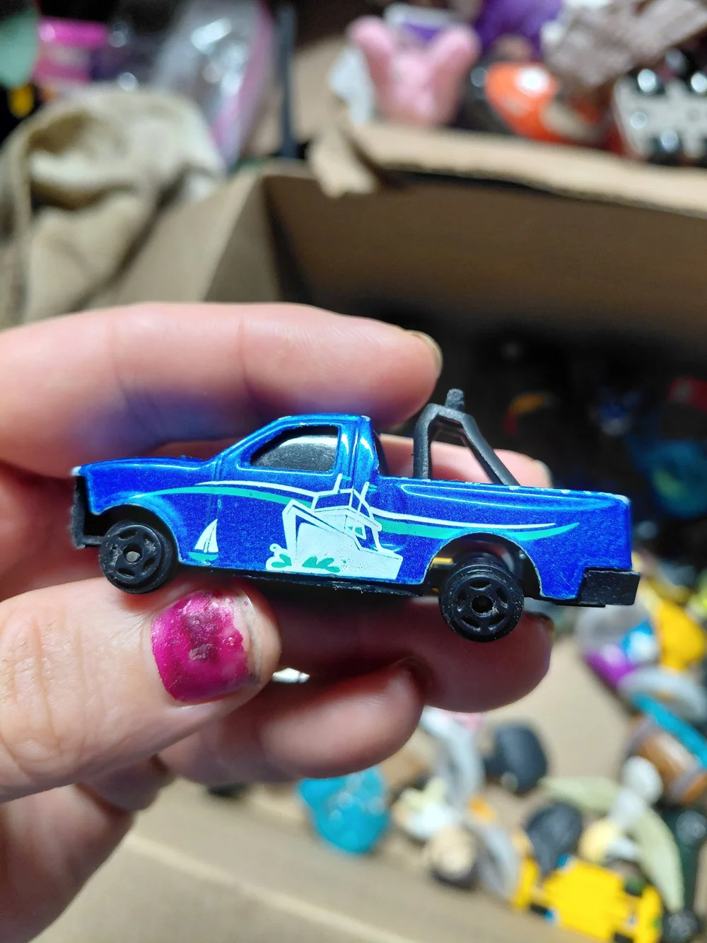 blue diecast pickup truck is a 1:64 scale model, possibly from a 