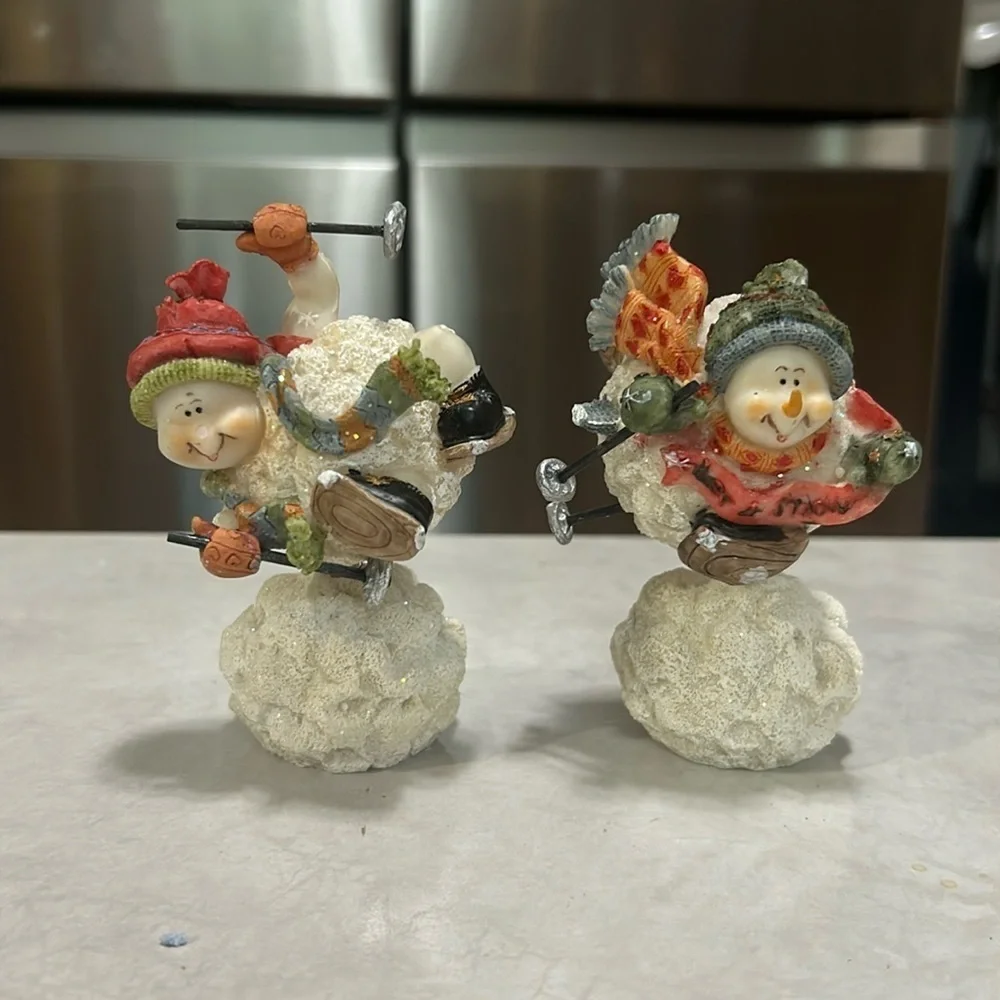 Set of snowmen sitting on snowball skiing